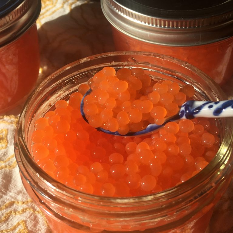 A spoonful of salmon caviar from a jar