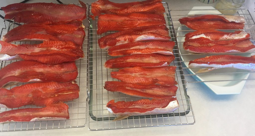 racks of salmon bellies lined up to be smoked