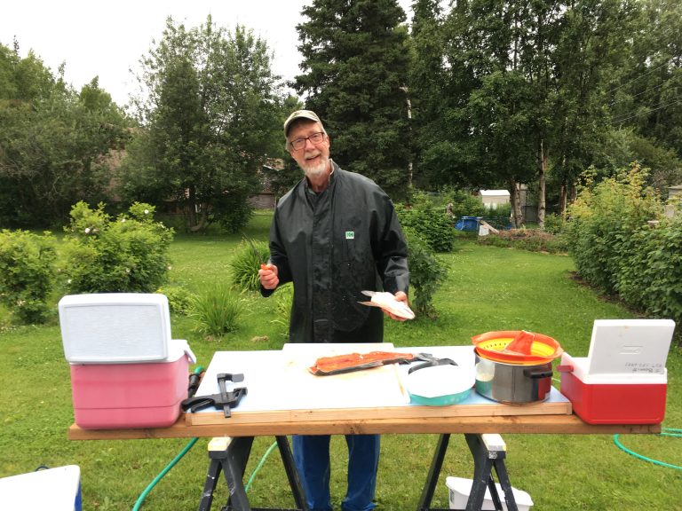 James P. Bennett stands a waist high table with his efficient set up for processing salmon