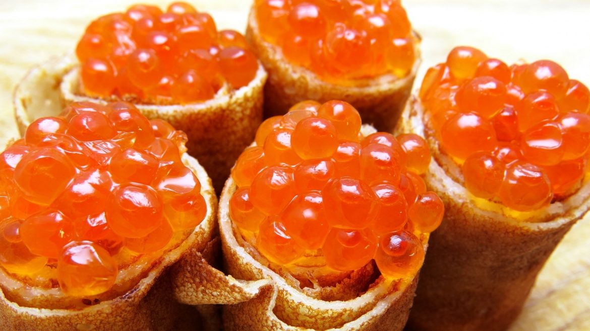 Rolled blini topped with salmon roe