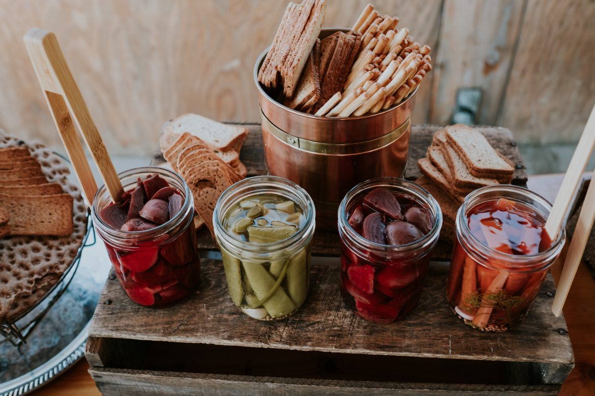 jars of pickled carrots, peas, and other veggies with bread and crackers