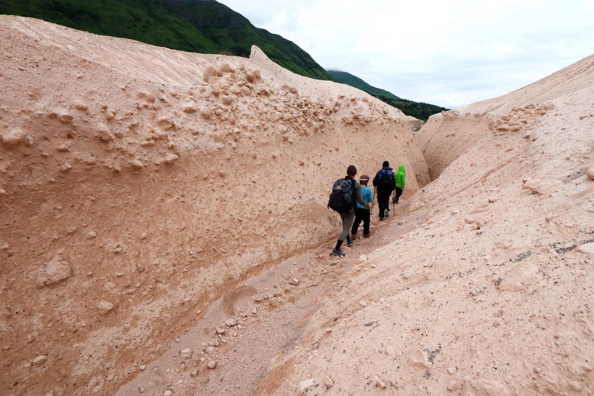 Family of four hiking into a dirt gully