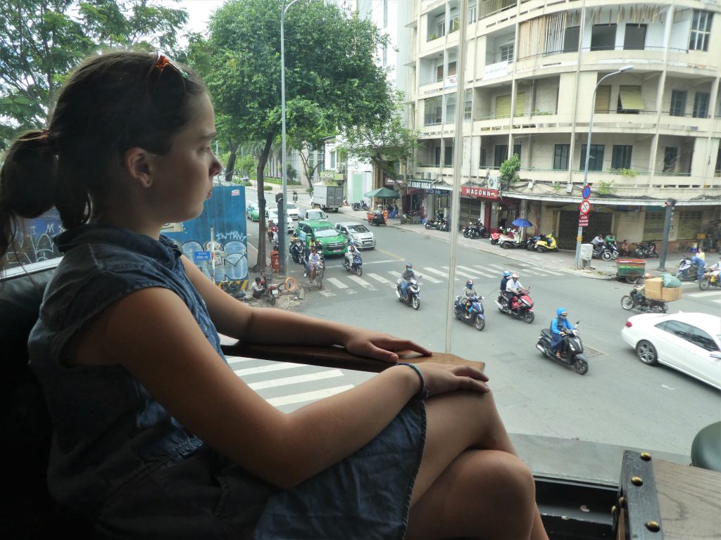 12-year-old Scout Gramse watches traffic in Ho Chi Minh city through her window.