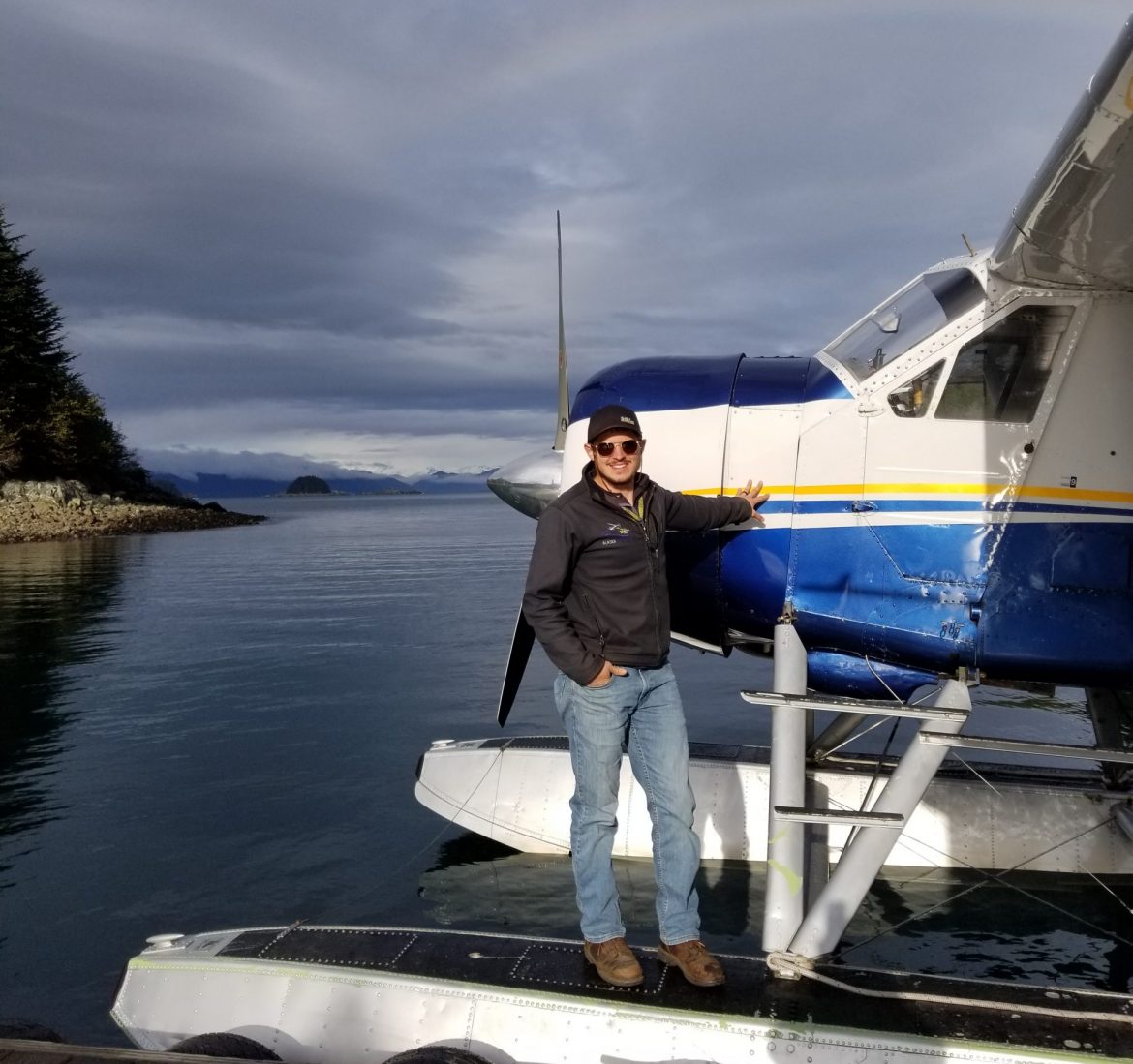 Bush pilot wearing jeans and a jacket standing on plane float.