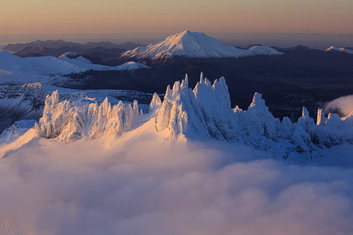 sharp peaks shrouded in snow emerge from clouds