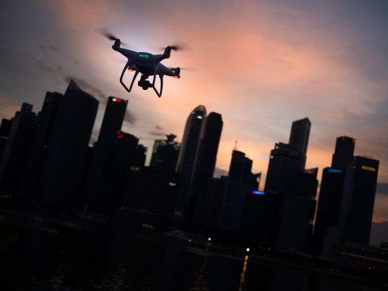Indemnis, Alaska startup, makes drone flight safer drone silhouette by city skyline