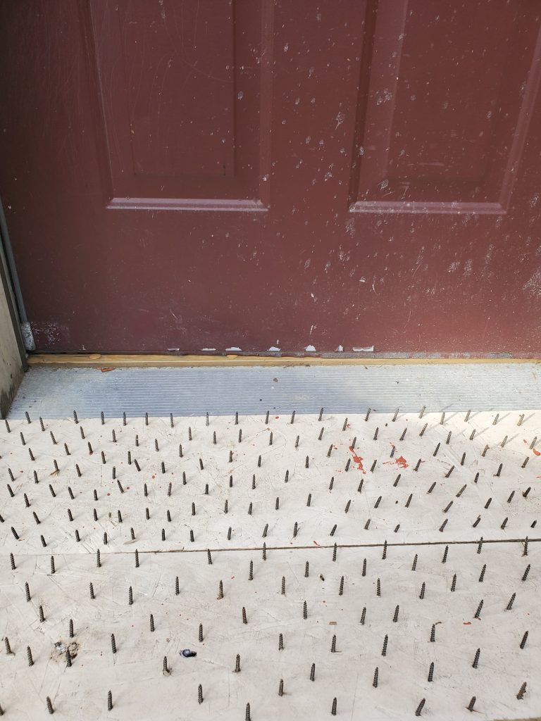 a board with screws laid in front of door to discourage bears