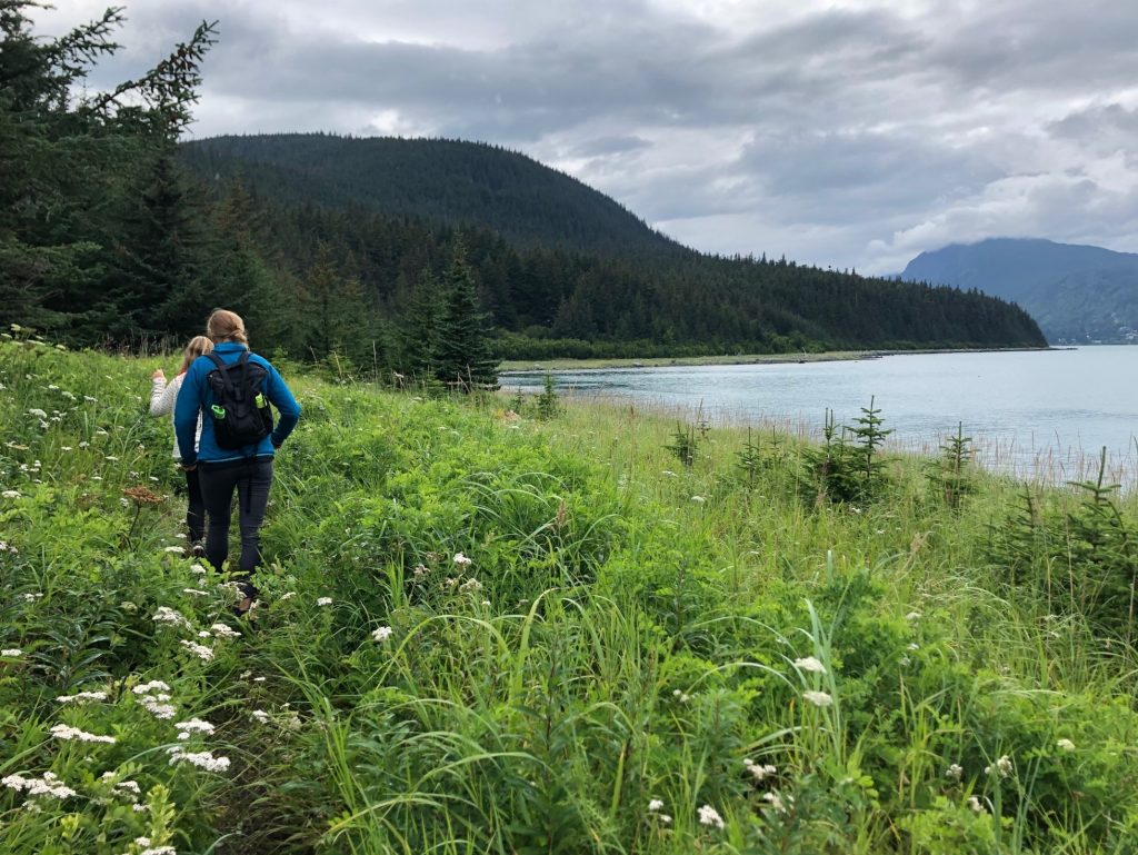 Heather Lende hiking on grassy shoreline
