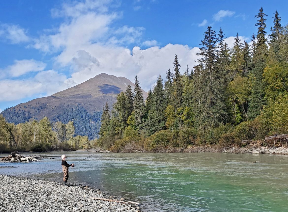 A lone fisherman on the bank of a river near Haines