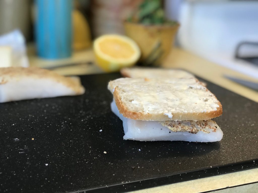 thin sourdough over halibut with butter on top