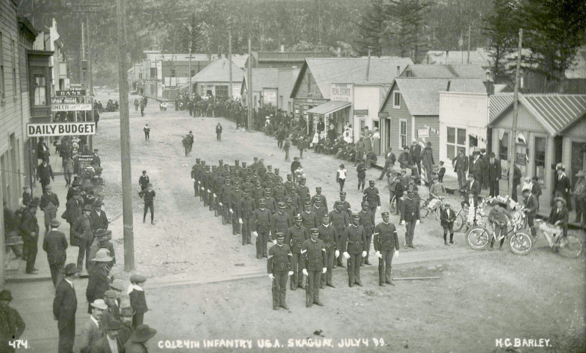 Soldiers line up in middle of street in black and white photo
