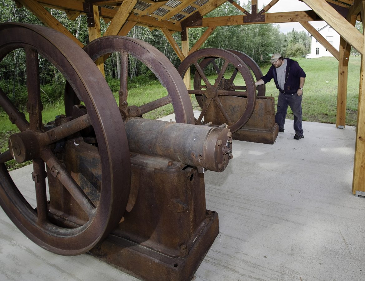 Old engines at Fort Egbert and a man viewing them