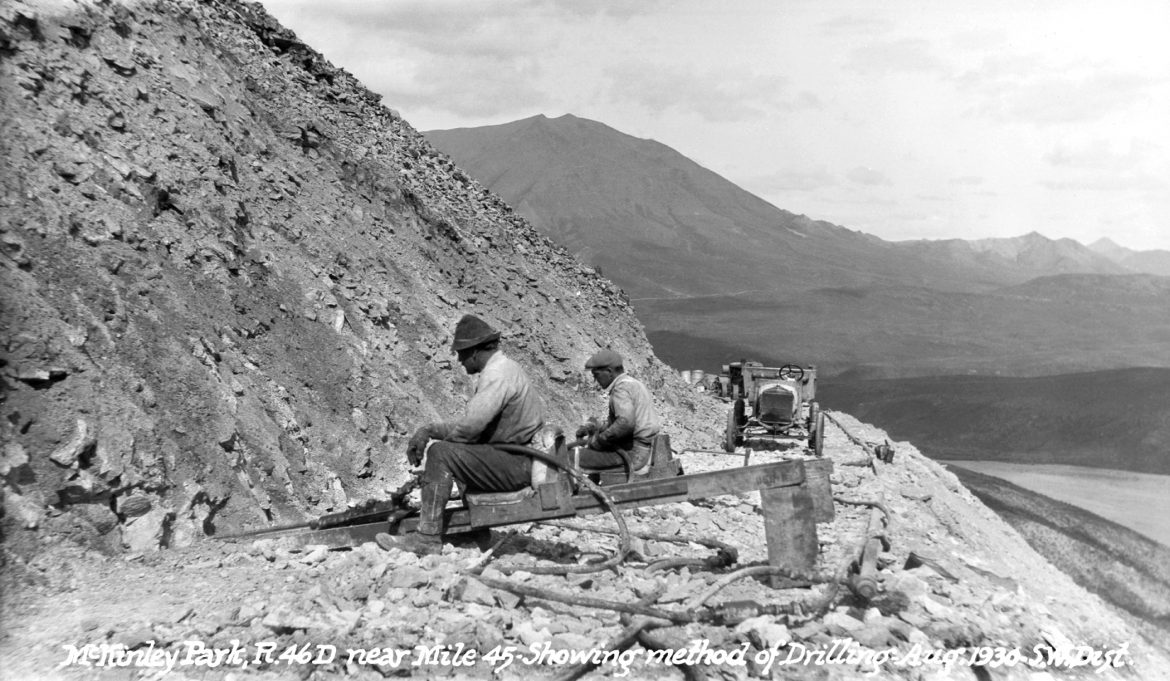 Men sit and rest while working on a mountainside road
