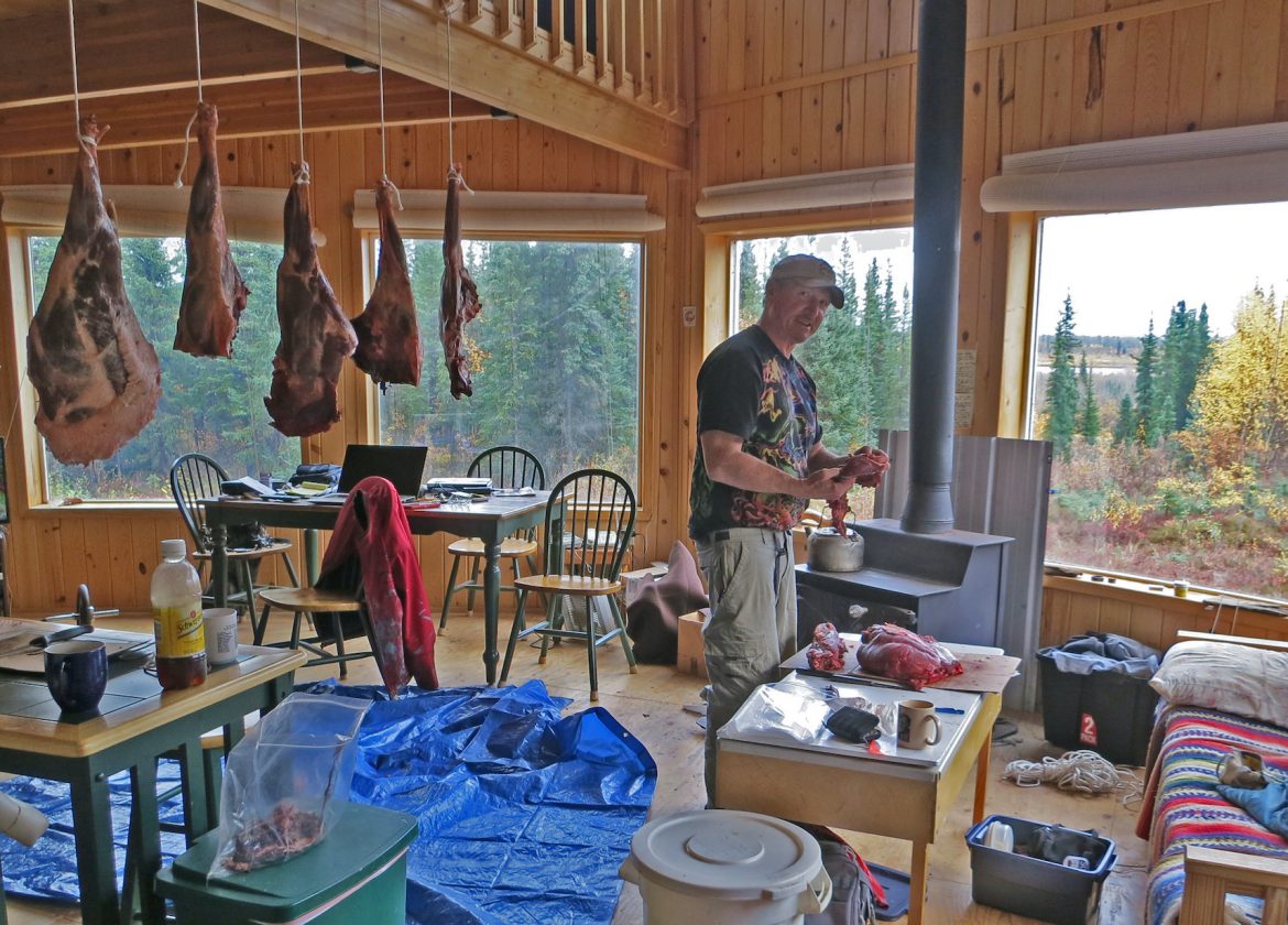 Nick Jans inside with cuts of caribou hang drying