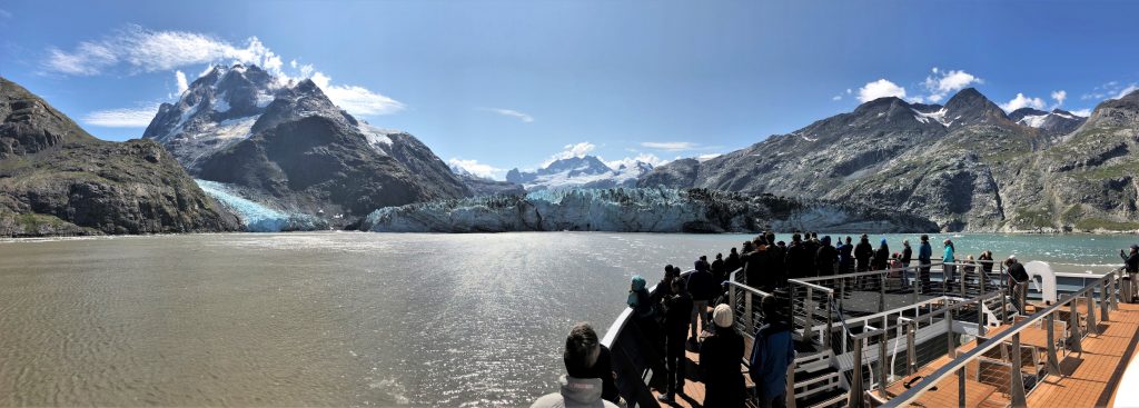 Bow of a cruise ship with passengers and glaciers ahead