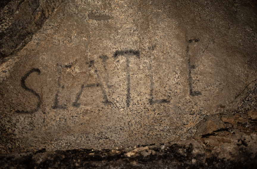 A carbide drawing of the word Seattle on rock wall