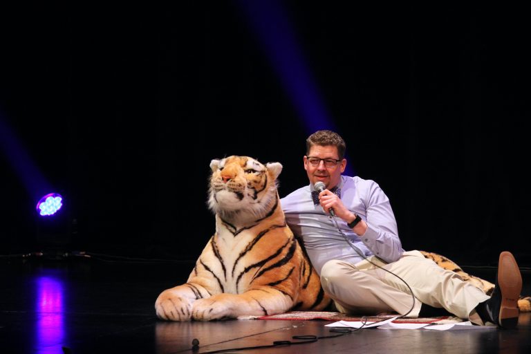 Dark Winter Nights creator Rob Prince on stage with a stuffed tiger