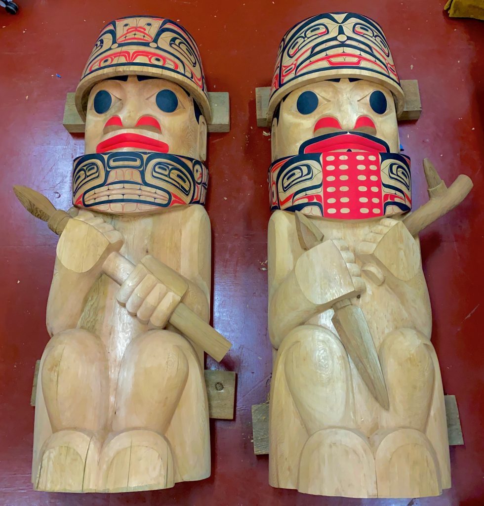 two painted totem poles. One male and one female warrior.