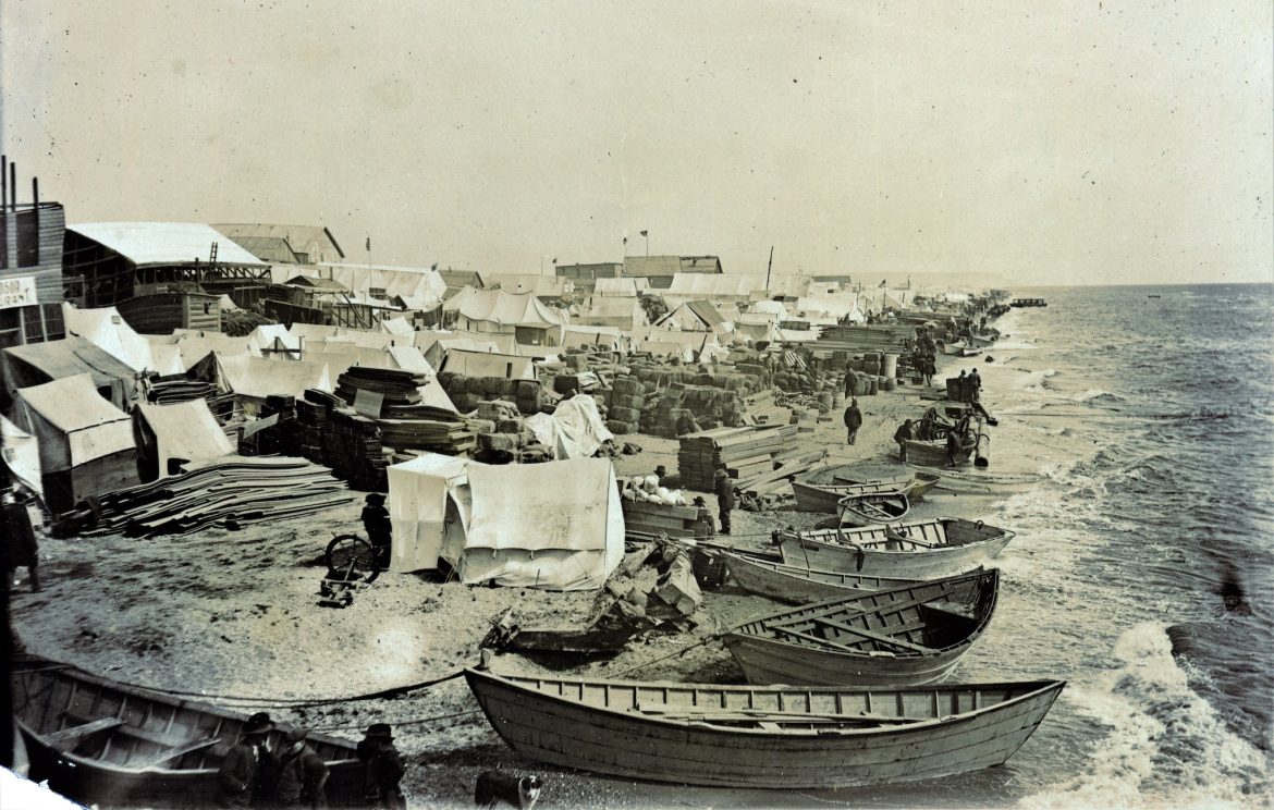 Fortune’s Distant Shores: A gold rush in Kotzebue Black and white photo of boats and tents lining a beach