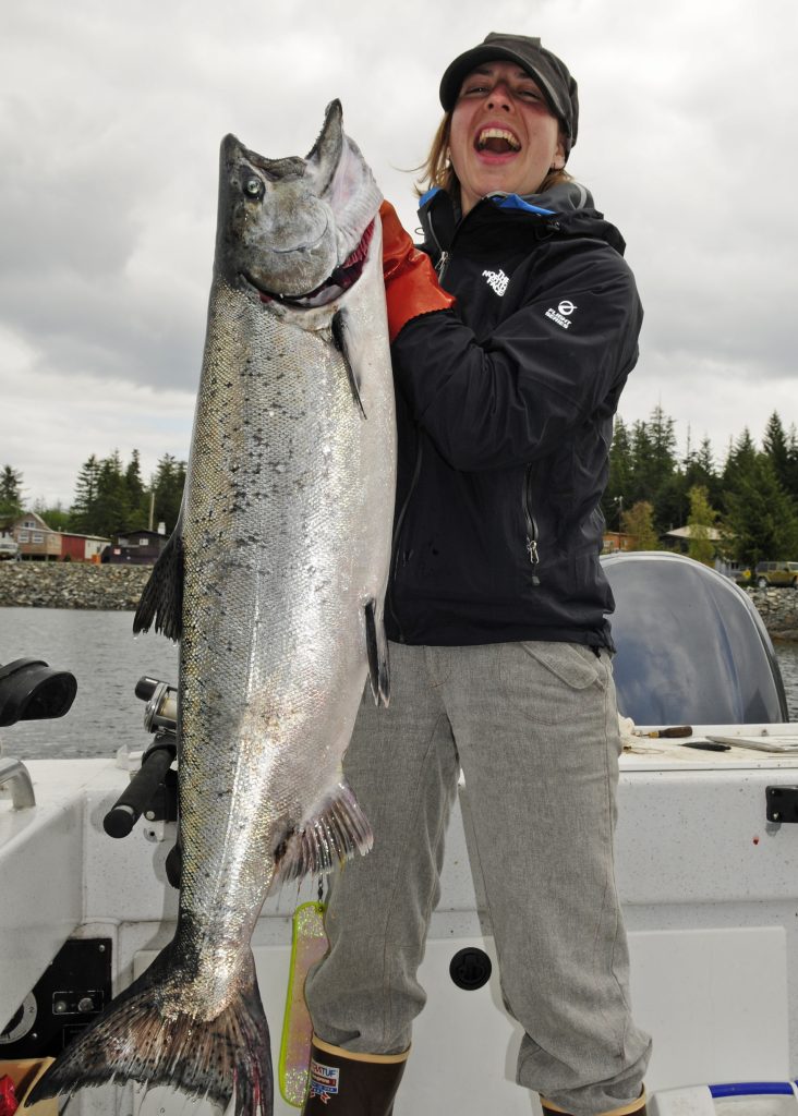 Angler looks thrilled while holding a large salmon by the gills