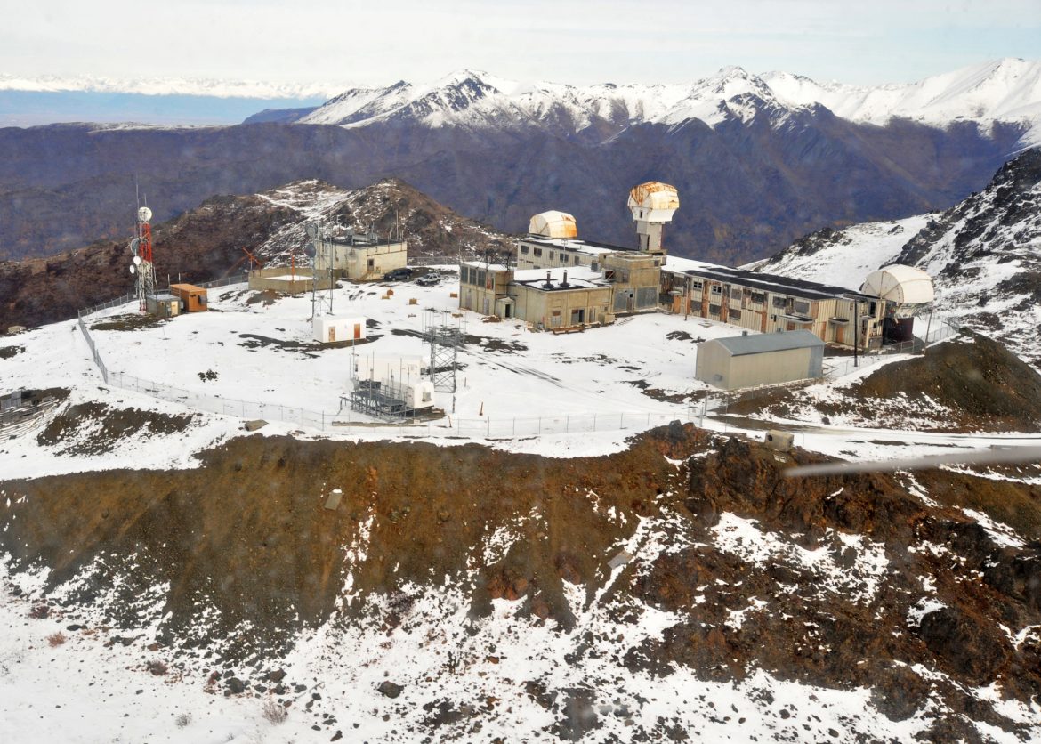 Nike Site Summit buildings scattered about a complex on a flattened mountain top still covered with patches of snow
