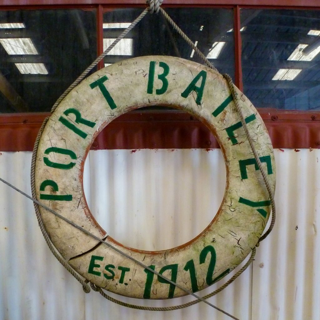 A white life ring with green lettering that reads, Port Bailey est. 1912