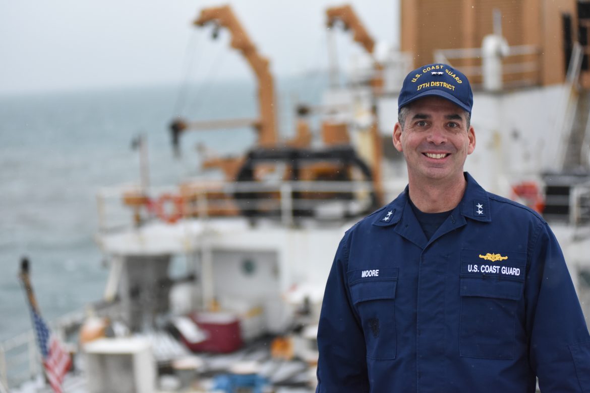 Coast Guard Admiral Nathan Moore smiling for photo in front of a coast guard cutter