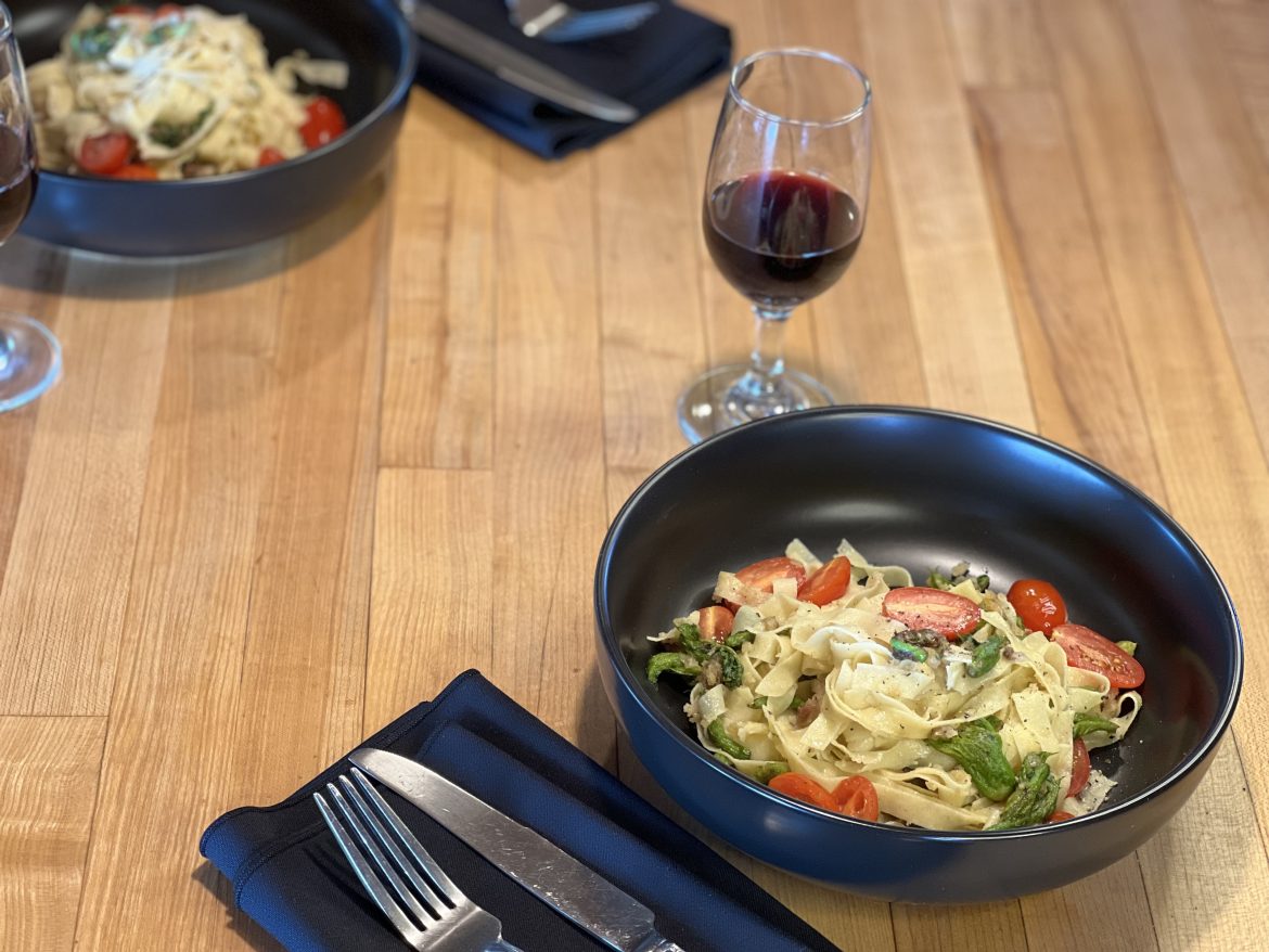 Devil's pasta alongside a glass of wine