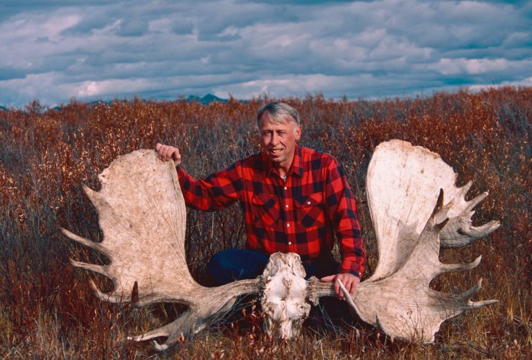 Van Ballenberghe poses with the antlered skull of a huge bull moose, one of many he followed over years of research.